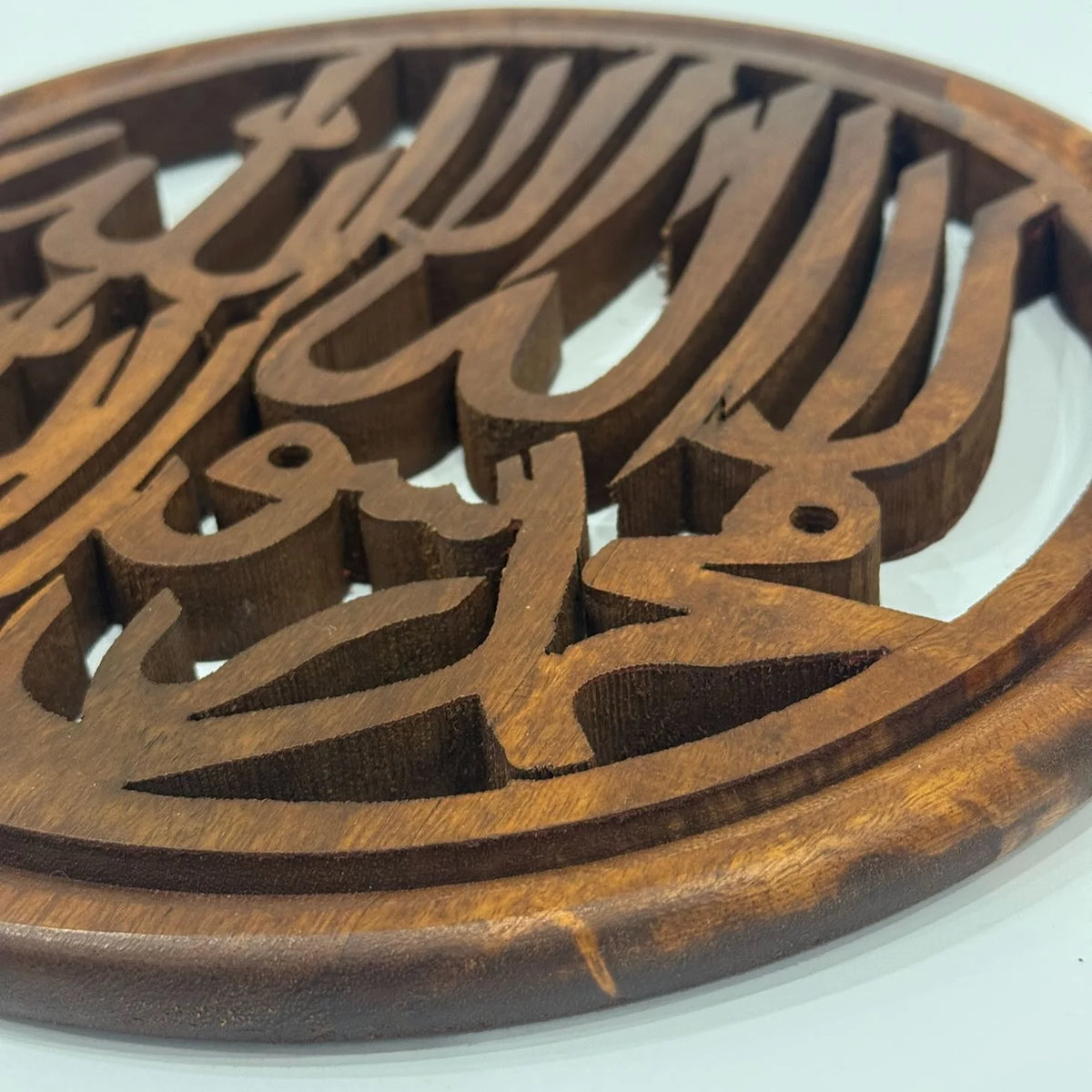Close-up of the carved Kalma lettering and rounded wooden frame