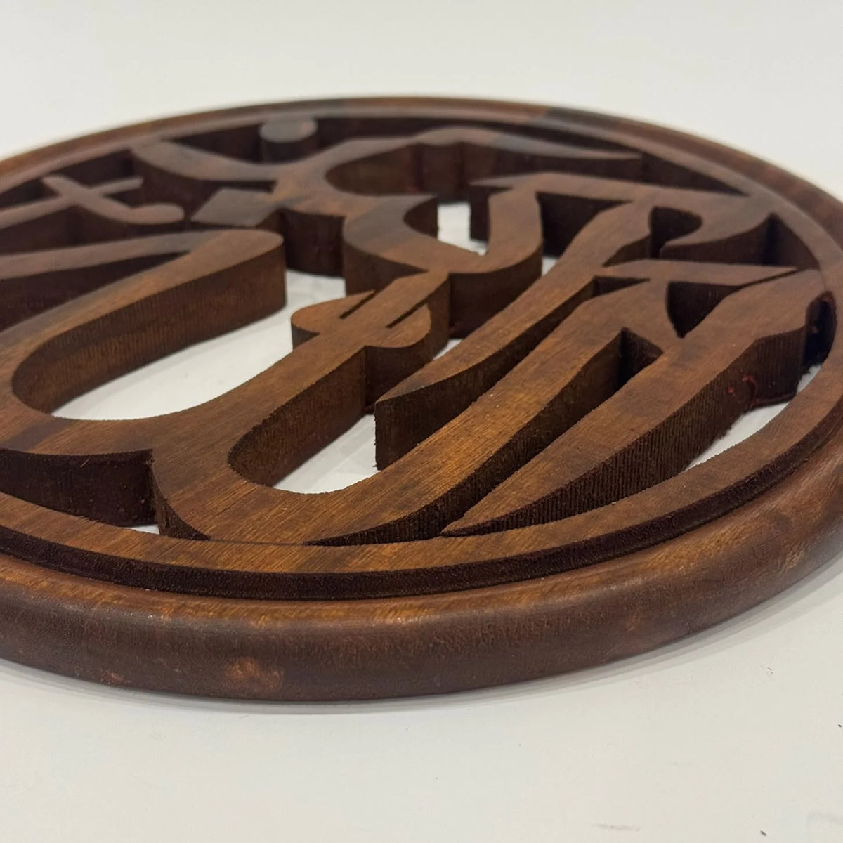 Close-up of the carved Masha'Allah lettering in solid wood