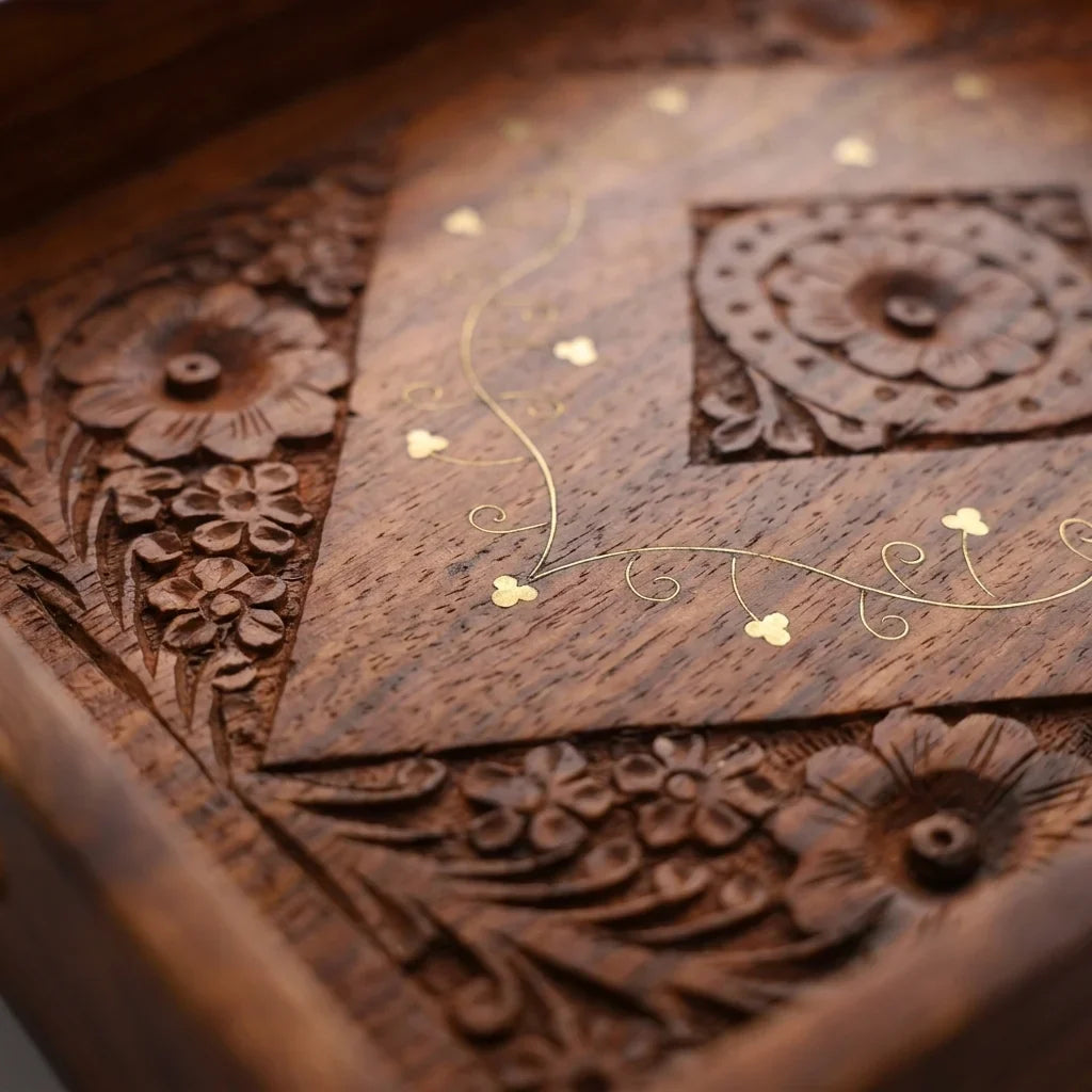 Close detail of the hand carved border and fine brass inlay on a Craft Edges sheesham serving tray