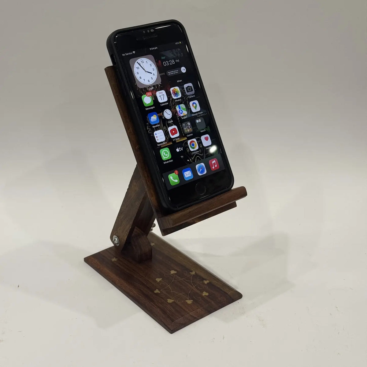 Sheesham wood mobile stand with brass inlay base holding a smartphone
