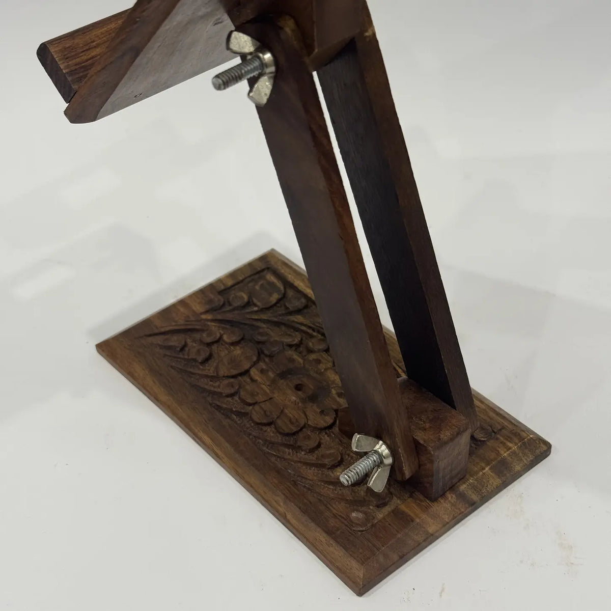 Adjustable arm and wing nuts on a hand carved wooden mobile stand, close-up