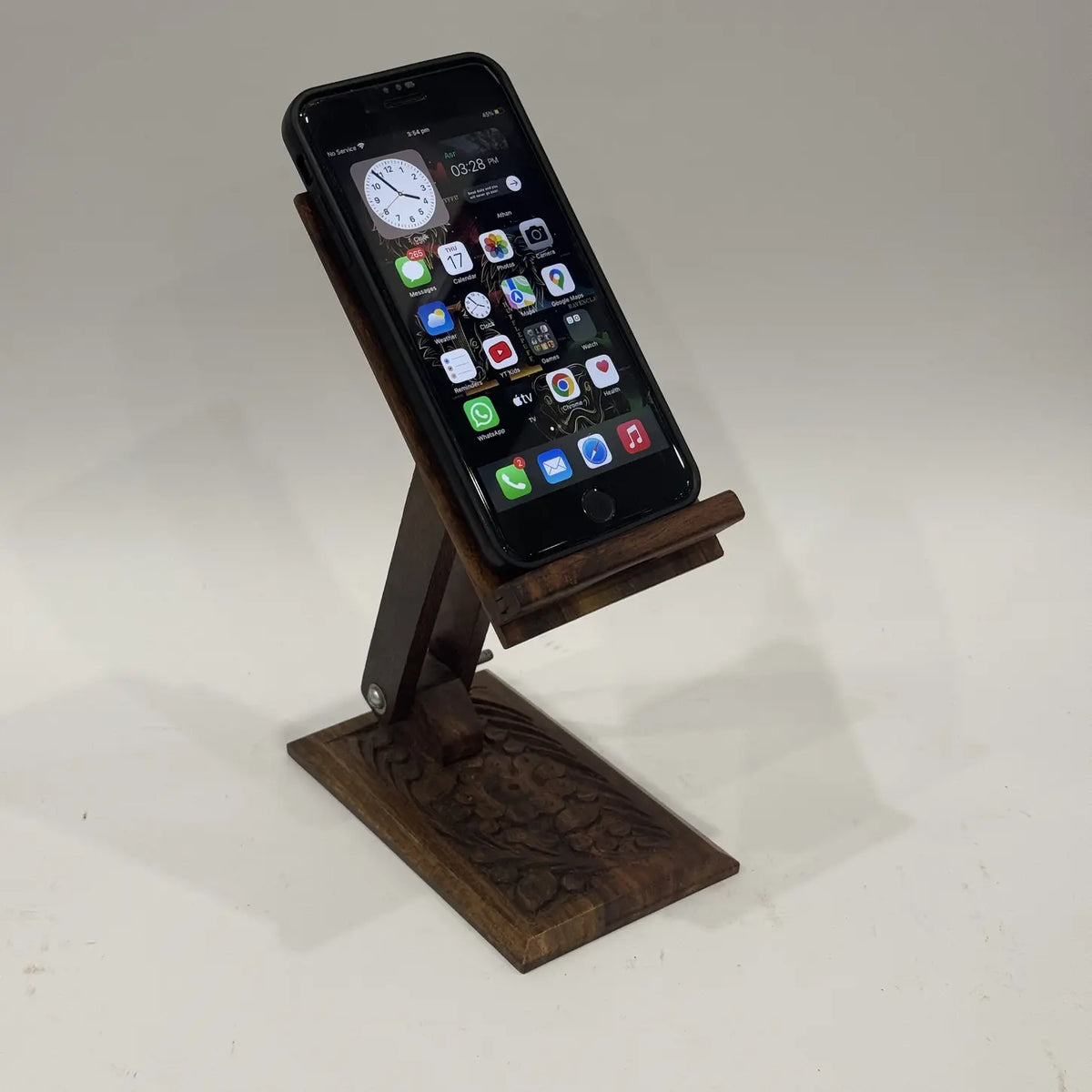 Hand carved wooden mobile stand with adjustable angle holding a smartphone
