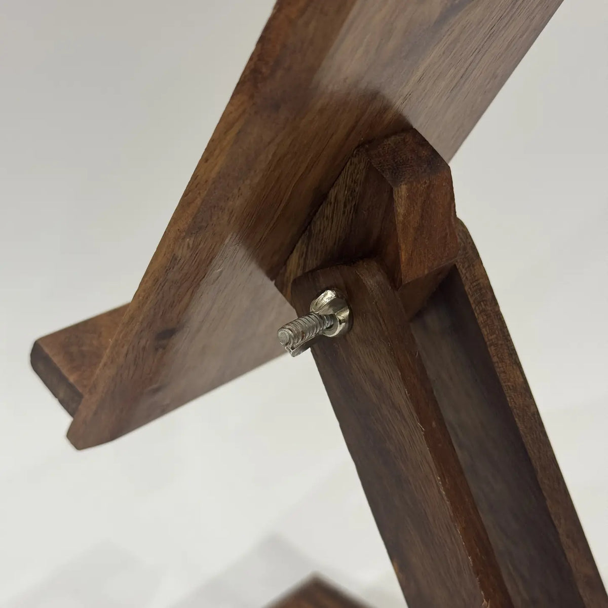 Close-up of the upper hinge and wing nut on an adjustable wooden mobile stand