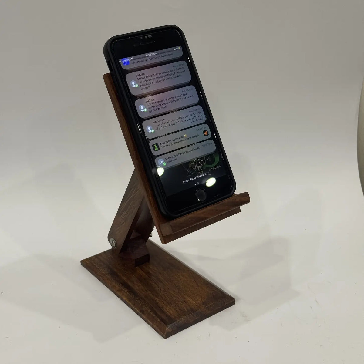 Plain wooden adjustable mobile stand holding a smartphone upright