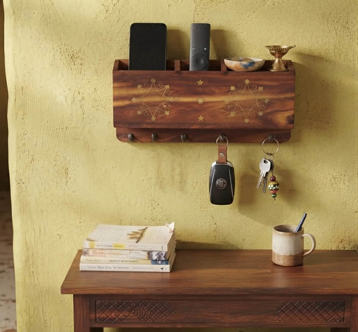 Brass inlay wooden wall organizer holding a phone, TV remote and small items, with car and house keys on the hooks